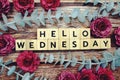 Hello Wednesday alphabet letter and flower decorate on wooden background