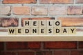 Hello Wednesday alphabet letter on shelves wooden background