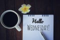 Hello Wednesday. Have a happy, beautiful and productive Wednesday concept. With morning coffee and text greeting on notepad.