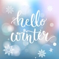 Hello winter banner. Brush calligraphy at blue winter background with snowflakes and bokeh lights. Vector card design Royalty Free Stock Photo