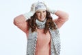 excited woman in sweater, mittens, hat and scarf on white