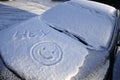 Hello winter! Snow, ice and a funny smiley on the hood of a car