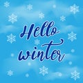 Hello winter text. Brush lettering on a blue winter background with snowflakes. Royalty Free Stock Photo