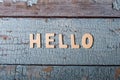 Hello wooden word written with wood letters on a wooden blue textured surface