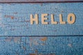 Hello wooden word written with wood letters on a wooden blue textured surface