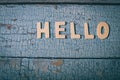 Hello wooden word written with wood letters on a wooden blue textured surface