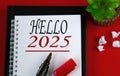 HELLO 2025 - word in white notebook on red background Royalty Free Stock Photo