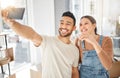 Hello world, look at what we have. A young couple taking selfies while holding the keys to their new house. Royalty Free Stock Photo