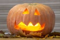 Helloween handmade pumpkin with leaves and light. Horror pumpkin Royalty Free Stock Photo