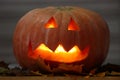 Helloween handmade pumpkin with leaves and candle light. Horror pumpkin Royalty Free Stock Photo