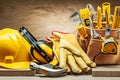 Helmet earphones hammer gloves and toolbelt with construction tools Royalty Free Stock Photo