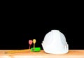 helmet plastic white with dart and measuring tape green. hat safety equipment working of engineering concept construction on Woode Royalty Free Stock Photo