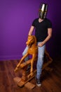 Helmeted knight on wooden rocking horse with purple wall and wooden floor