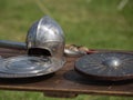 Helmets, Shields and Medieval Metallic Armors and Weapons, Outdoors on Wooden Table