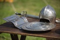 Helmets, Shields and Medieval Metallic Armors and Weapons, Outdoors on Wooden Table Royalty Free Stock Photo