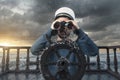 helmsman with binoculars and cap on stormy seas viewing the coast Royalty Free Stock Photo