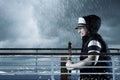 Helmsman with vest and cap struggle against storm in front of st