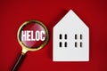 HELOC Home Equity Lines Of Credit text with house model on red background Royalty Free Stock Photo