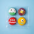 Heloween dessert: set of funny monsters, ghost, spider made of biscuits macaroon with icing and candy eyes close-up in plastic box Royalty Free Stock Photo