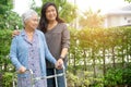 Help and care Asian senior or elderly old lady woman use walker with strong health while walking at park in fresh holiday Royalty Free Stock Photo