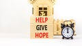 Help give hope symbol. Concept word Help give hope on beautiful wooden block. Black alarm clock. Beautiful white table white Royalty Free Stock Photo