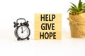 Help give hope symbol. Concept word Help give hope on beautiful wooden block. Black alarm clock. Beautiful white table white Royalty Free Stock Photo