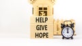 Help give hope symbol. Concept word Help give hope on beautiful wooden block. Black alarm clock. Beautiful white table white Royalty Free Stock Photo