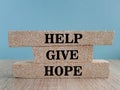 Help give hope symbol. Concept word Help give hope on brick blocks. Beautiful wooden table, blue background. Business motivational Royalty Free Stock Photo