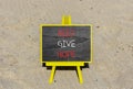 Help give hope symbol. Concept word Help give hope on beautiful black chalk blackboard. Sand beach. Beautiful sand beach Royalty Free Stock Photo