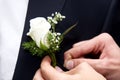 Help the groom to pin a wedding flower to suit