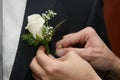 Help the groom to pin a wedding flower to suit