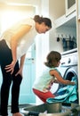 Help, home and mom with kid at washing machine for chores, teaching and learning housekeeping routine. Laundry, mother Royalty Free Stock Photo