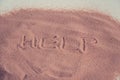 `Help` inscription on the sand