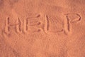 `Help` inscription on the sand