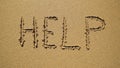 Help - inscription on the sand by the ocean