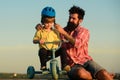 Help kid explore world. Happy loving family Father and son. Little boy wearing helmet while learning to ride cycle with Royalty Free Stock Photo