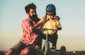 Help kid explore world. Happy loving family Father and son. Little boy wearing helmet while learning to ride cycle with Royalty Free Stock Photo