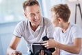 Pre-teen boy asking father how to open VR headset