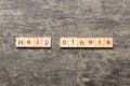 Help others word written on wood block. Help others text on table, concept Royalty Free Stock Photo