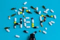 Help sign made of colorful pills spilled from a bottle on a blue Royalty Free Stock Photo