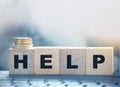 Help - text on wooden cubes puton computer keyboard with stack of coins. Donation and charity concept. Business startup Royalty Free Stock Photo