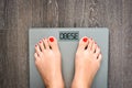 Help to lose kilograms with woman feet stepping on a weight scale Royalty Free Stock Photo