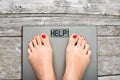 Help to lose kilograms with woman feet stepping on a weight scale