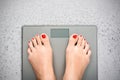 Help to lose kilograms with woman feet stepping on a weight scale