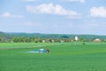 With the help of a tractor, wheat is sprayed with fertilizers or herbicides in rural areas.