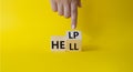 Help vs Hell symbol. Businessman hand points at turned wooden cubes with words Hell and Help. Beautiful yellow background.