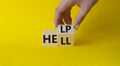 Help vs Hell symbol. Businessman hand Turnes cube and changes word Hell to Help. Beautiful yellow background. Psychology and Help