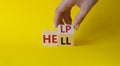 Help vs Hell symbol. Businessman hand Turnes cube and changes word Hell to Help. Beautiful yellow background. Psychology and Help