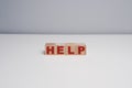 Help word written on cube shaped wooden blocks on a white colored table Royalty Free Stock Photo