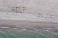 Help written on exotic sand beach with tropic blue sea. Royalty Free Stock Photo